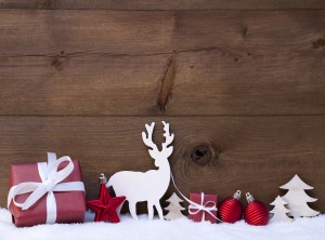 Christmas Card With Red Festive Decoration On Snow. Christmas Gift, Present, Reindeer, Christmas Ball, Christmas Tree, Star. Brown, Rustic, Vintage Wooden Background With Copy Space For Advertisement